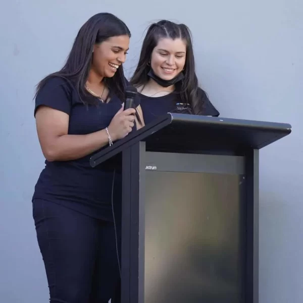 two women speaking behind a lectern